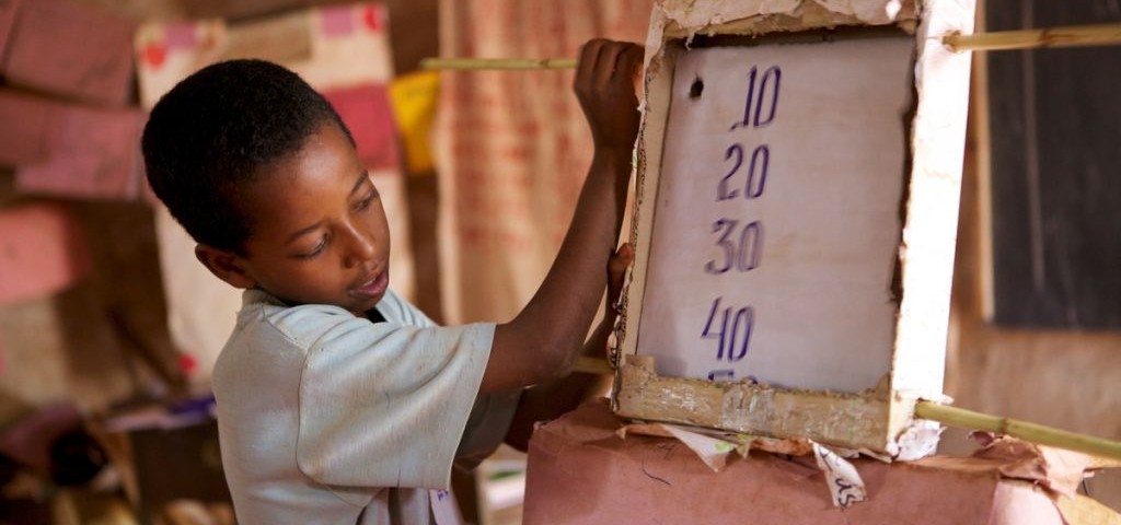 young boy at school using a board to do maths