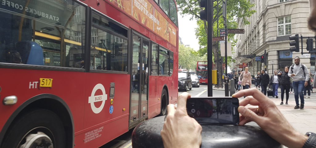 smartphone filmmaking course. A person films a London bus using a mobile phone