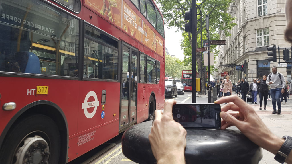 smartphone filmmaking course. A person films a London bus using a mobile phone