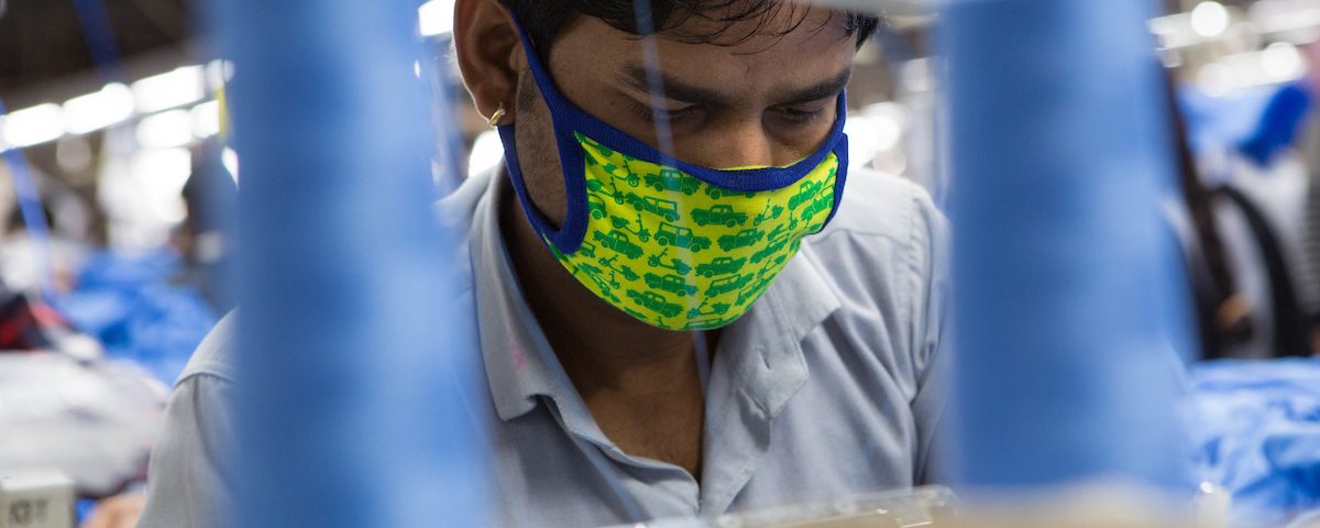 A man working on a sewing machine in an Indian organic cotton factory.