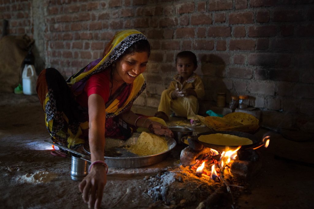 Women cooking chapattis on an open fire, India.