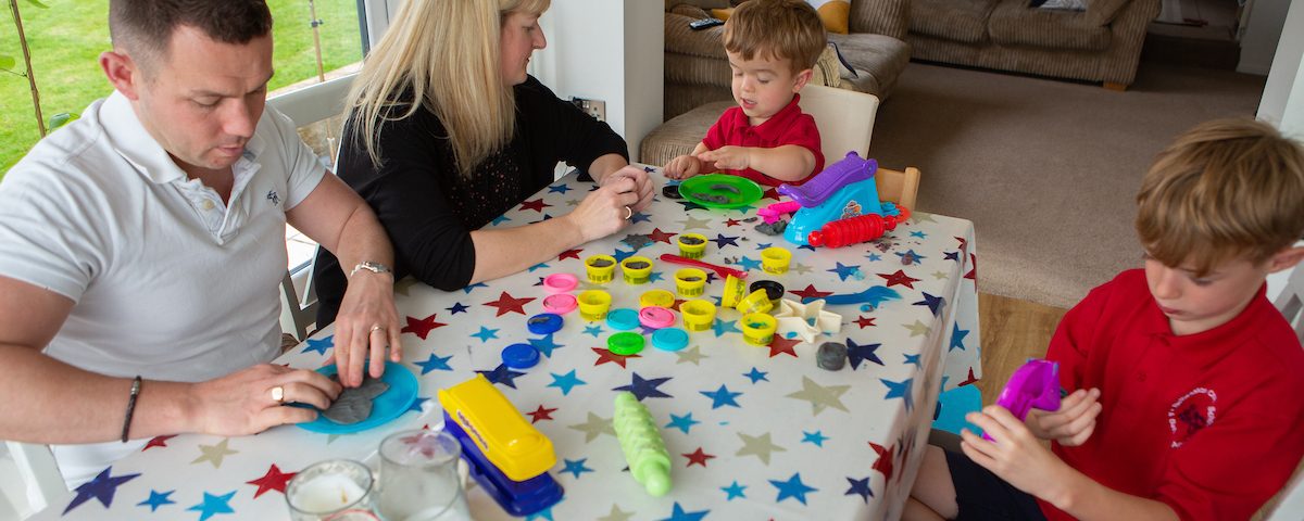 a young carer playing with play doh around the kitchen table