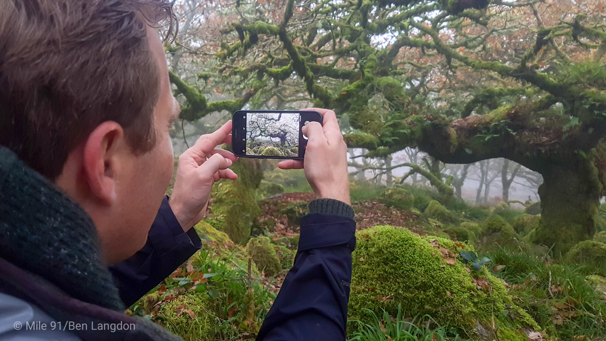 man gathering stories filming in Dartmoor with smartphone